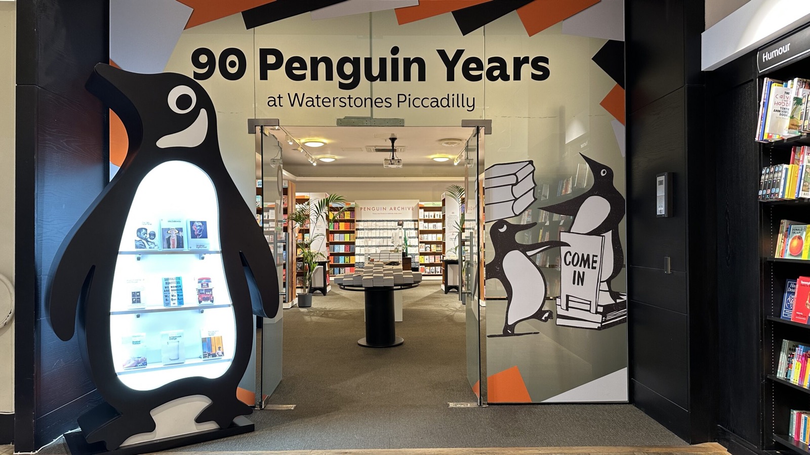 The 90 Penguin Years retail activation at Waterstones Piccadilly in London, with an illuminated giant penguin at the shop entrance