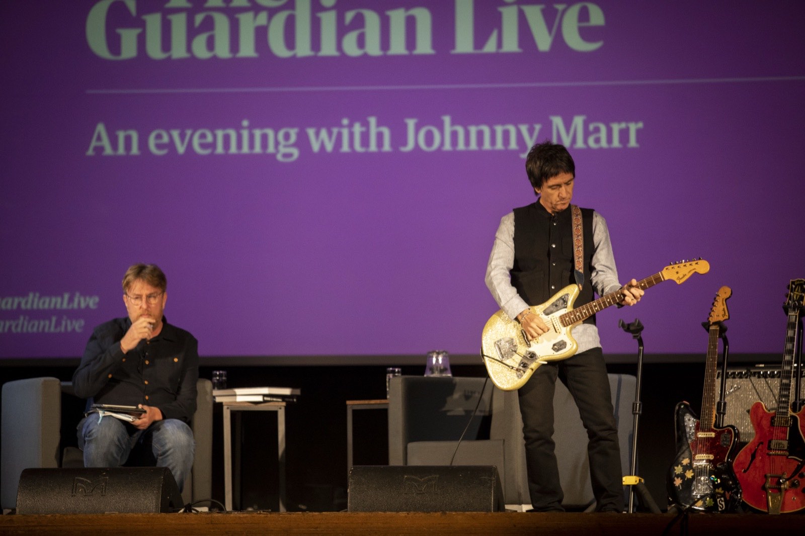 Johnny Marr playing guitar on stage during an evening with Guardian Live