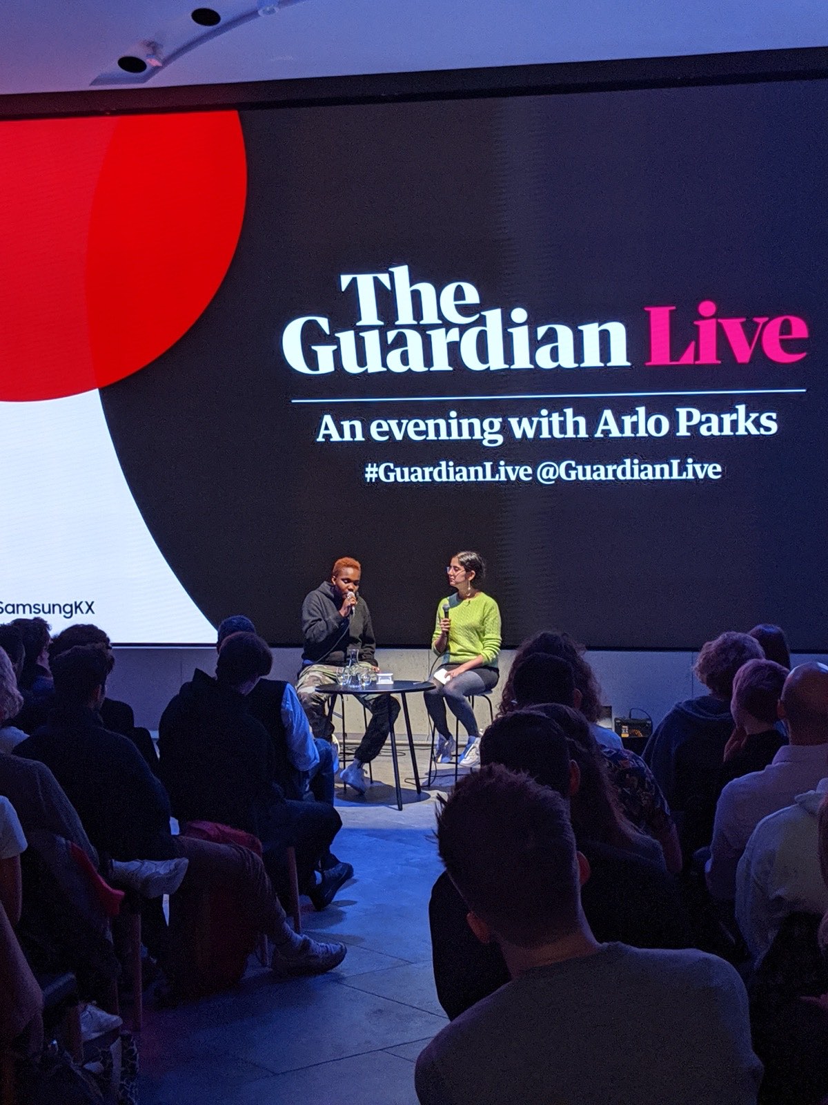 Arlo Parks in conversation in front of a seated audience at a Guardian Live event