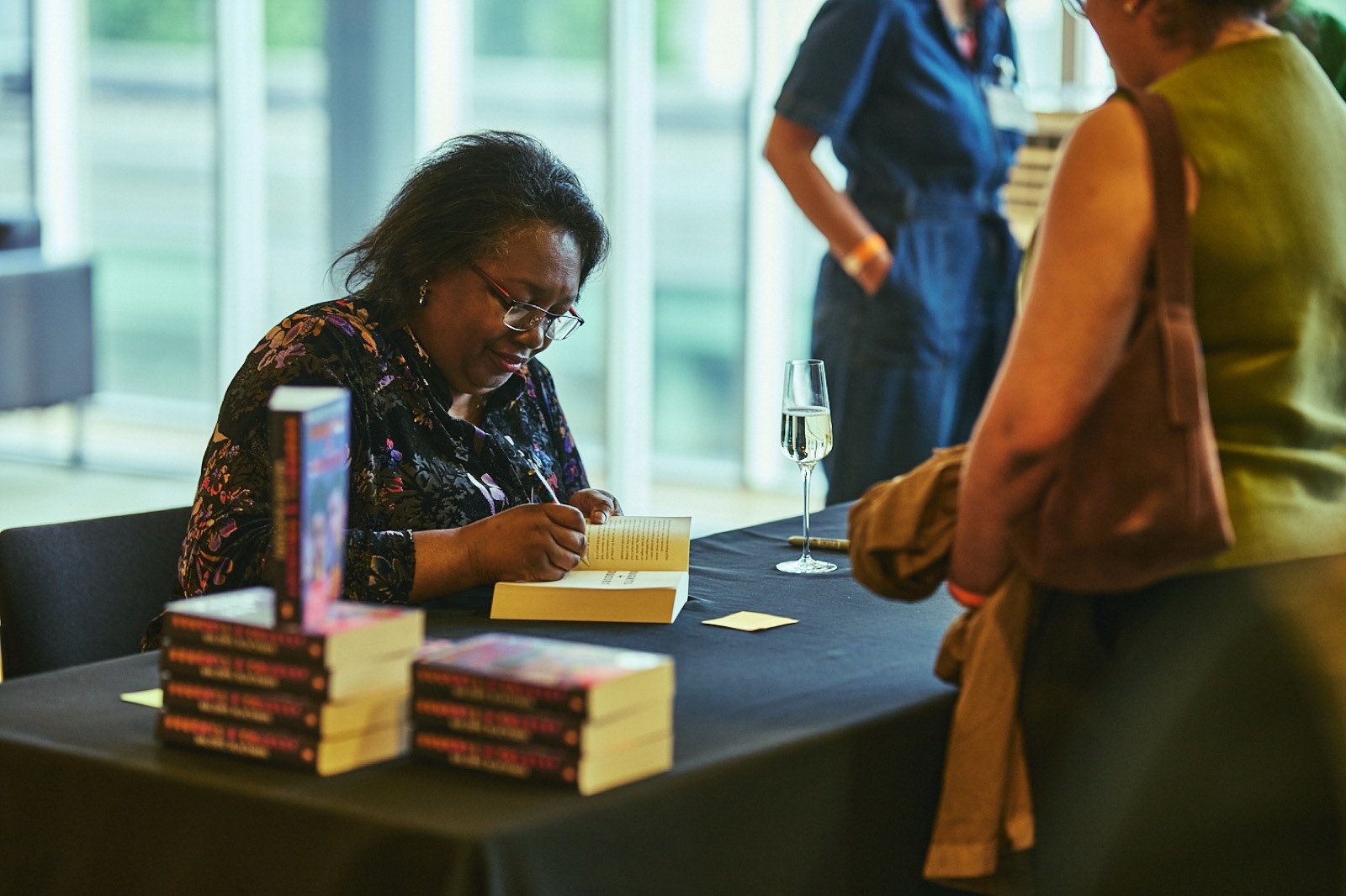 An author signing books for readers at a Penguin Presents event